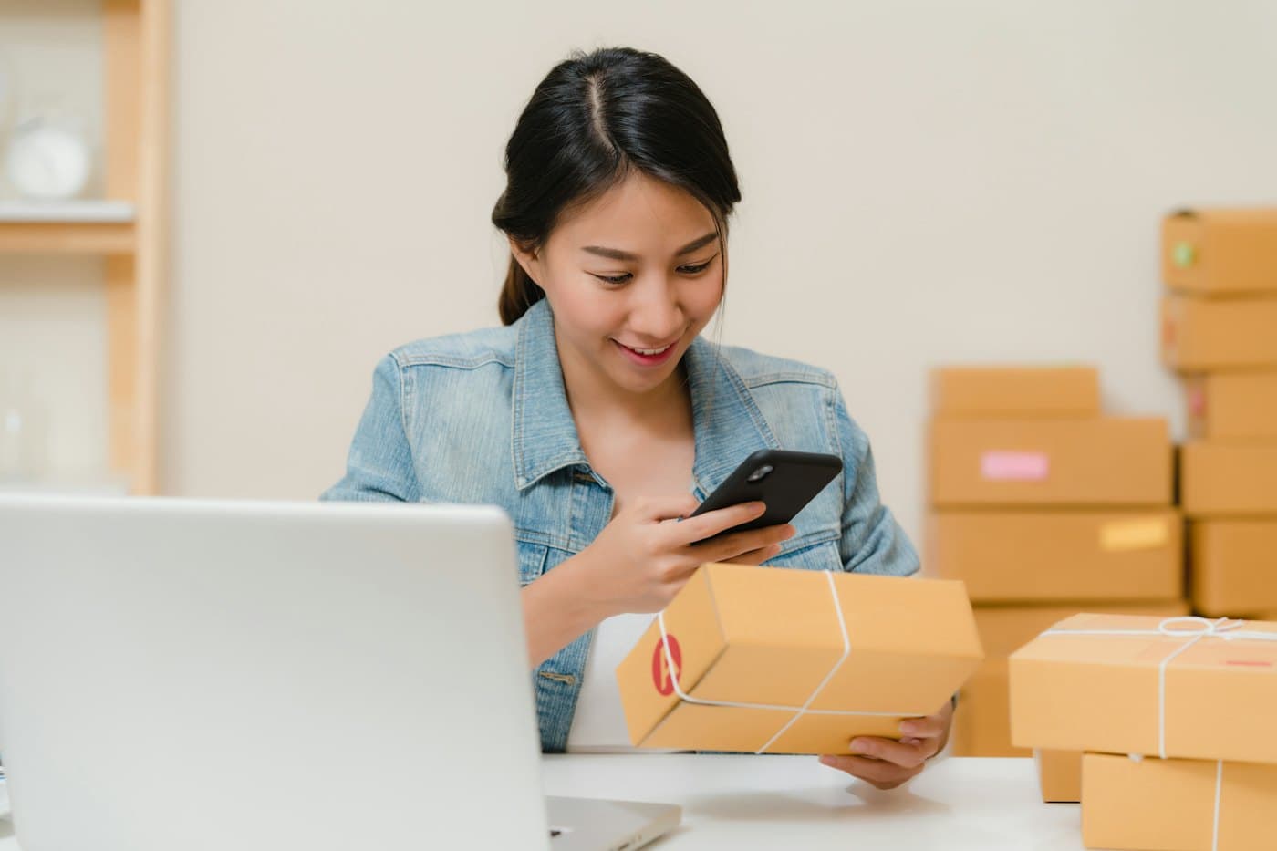 Emprendedora revisando pedidos entre cajas